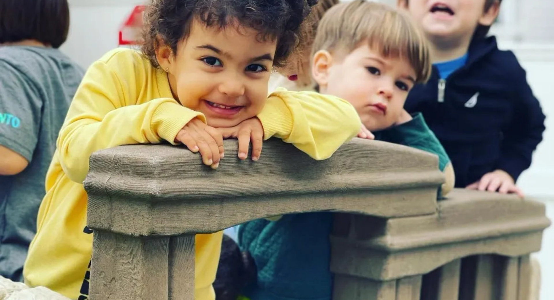 Smiling young child in a yellow sweatshirt