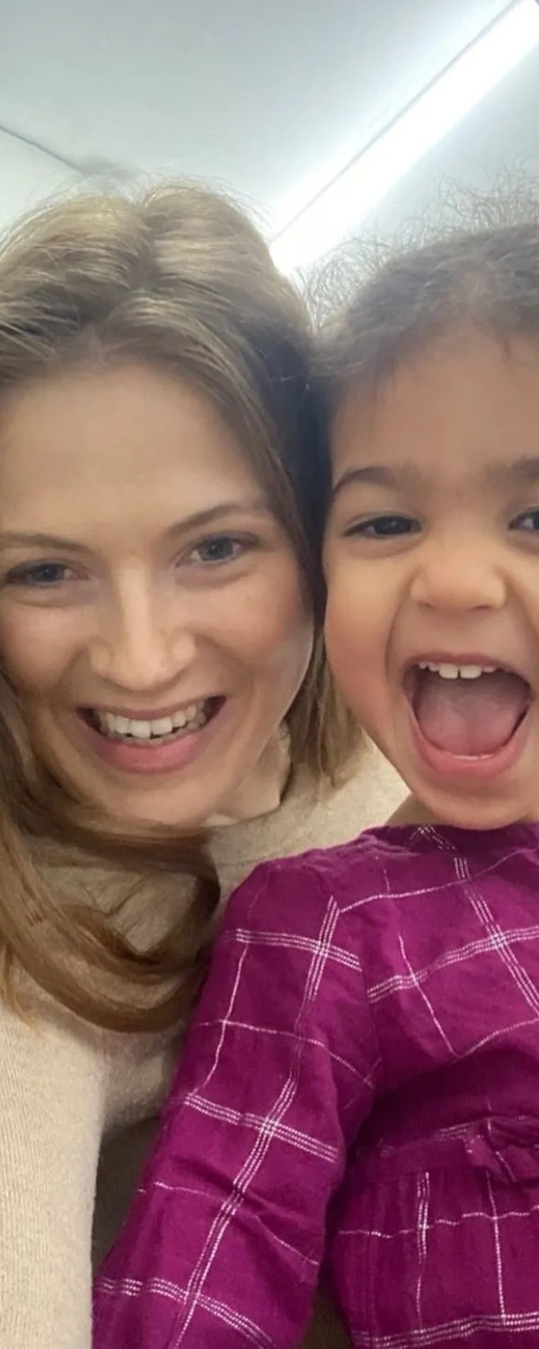 Smiling adult posing for a close-up selfie with two young children