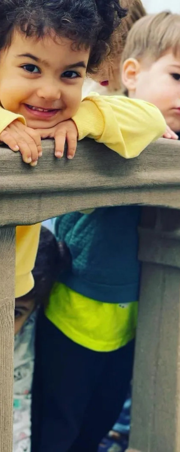 Smiling young child in a yellow sweatshirt